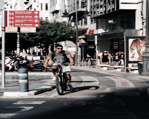 A person cycling in a dedicated bike lane in a Spanish city